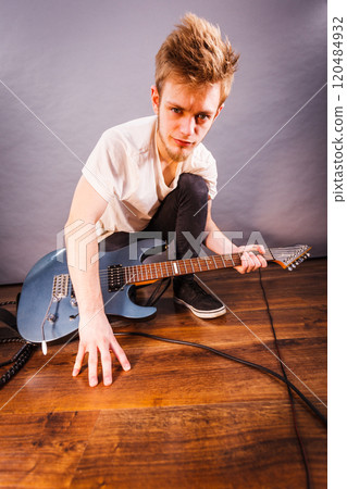 Man setting up guitar equipment Man setting up guitar equipment 120484932
