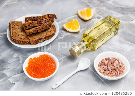 Red salmon caviar, rye bread and cooking oil on the kitchen table. 120485290