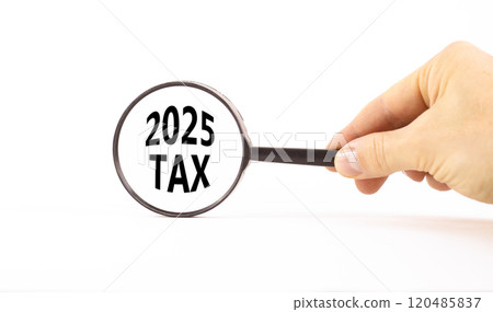 Planning 2025 tax new year symbol. Concept words 2025 Tax on beautiful white paper in magnifying glass. Businessman hand. Beautiful white background. Business 2025 tax new year concept. Copy space. 120485837
