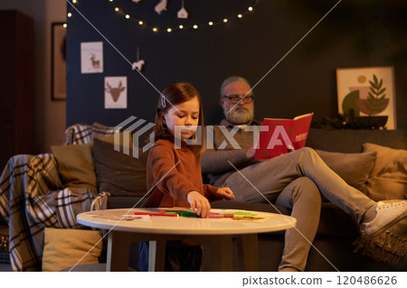Child Playing While Bearded Man Reading Book 120486626