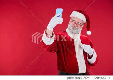 Santa Taking Selfie with Smartphone in Red Costume 120486704