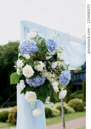 A beautifully adorned wedding arch featuring elegant blue and white flowers 120486833