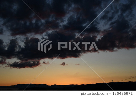 A view of the outskirts of Nanyo City, where the sunset colors the sky and clouds. 120486971
