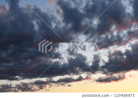 A landscape where orange light is dyeing a large amount of clouds 120486973