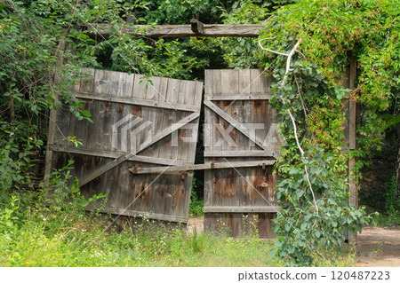 Old wooden gate in countryside. Traditional wooden farmhouse. Village ethnographic museum. Vintage exterior. Sunny day. Old wooden gate in countryside. Traditional wooden farmhouse. Village ethnographic museum. Vintage exterior. Sunny day. 120487223