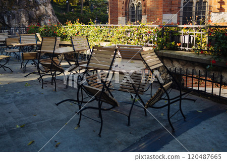 Outdoor cafe interior. simple, tasteful tables with chairs at city park.Golden foliage in late fall. Beautiful nature.  120487665