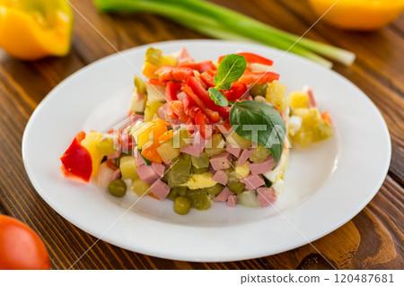 vegetable salad of boiled vegetables, with peas, sausage, sweet pepper. On a wooden table vegetable salad of boiled vegetables, with peas, sausage, sweet pepper. On a wooden table 120487681