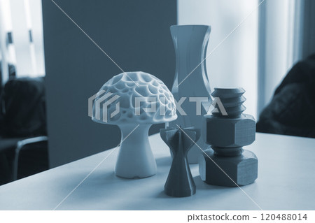 Several art objects printed on a 3D printer. Model blue vase, white mushroom, tip, gray washer and bolt created 3D printer from molten plastic. Additive progressive technology Several art objects printed on a 3D printer. Model blue vase, white mushroom, tip, gray washer and bolt created 3D printer from molten plastic. Additive progressive technology 120488014