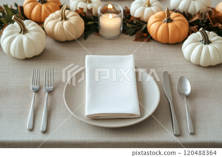 Elegant dining table setting with white pumpkins and candle, autumn decor. 120488364