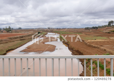 River Flowing Through Farmlands with Locals Washing Clothes. River Flowing Through Farmlands with Locals Washing Clothes. 120489278
