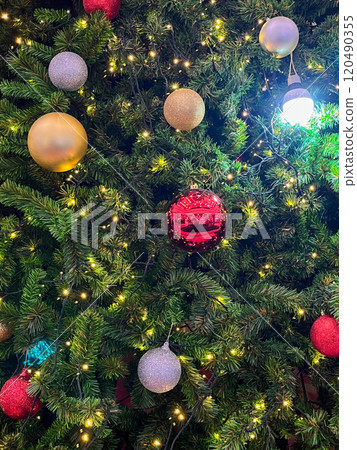 A beautifully decorated Christmas tree adorned with colorful ornaments 120490355