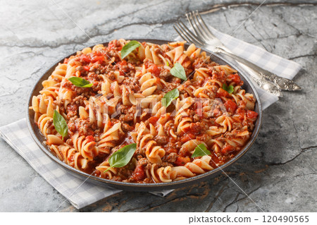 Spicy fusilli pasta with meat bolognese sauce close-up in a plate. Horizontal 120490565