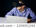 A person uses virtual reality on a laptop, blending technology with productivity and innovation in a modern workspace 120491244