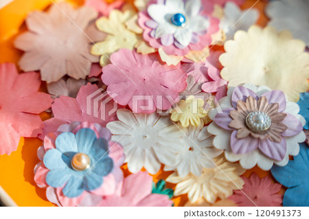 Small, colorful paper flowers for creativity of 3D flowers as a background. Child development toy Small, colorful paper flowers for creativity of 3D flowers as a background. Child development toy 120491373