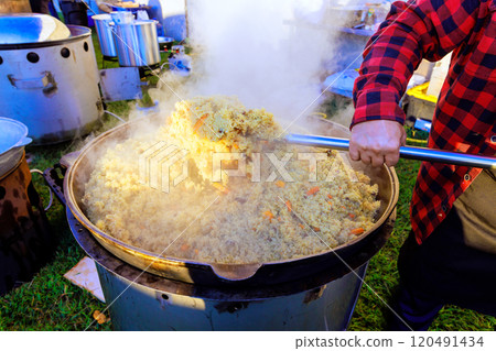 Traditional Turkish pilaf is cooked in large cast iron cauldron while cuisine is being prepared 120491434