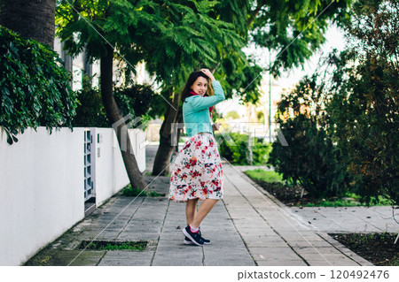 a young woman in a floral dress on the streets of Cyprus in December a young woman in a floral dress on the streets of Cyprus in December 120492476