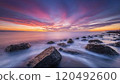 a rocky shoreline at sunset 120492600