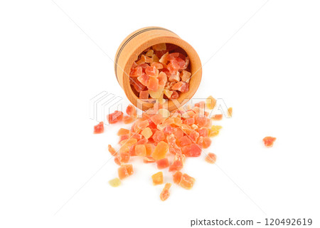 Dried pieces of papaya in a wooden bowl isolated on white. Dried pieces of papaya in a wooden bowl isolated on white. 120492619