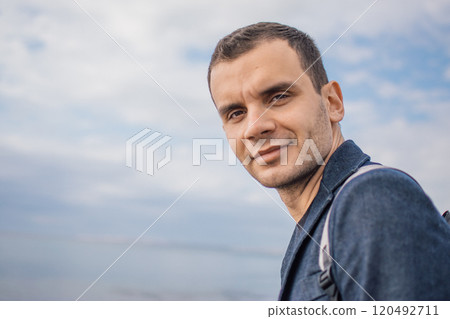young man with a backpack on the seashore 120492711