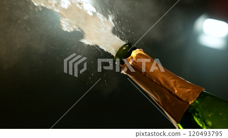 Freeze motion of Champagne explosion with flying cork closure, opening champagne bottle closeup. 120493795