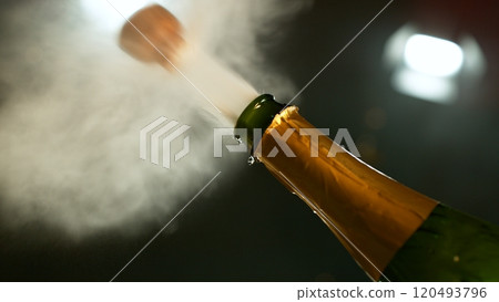 Freeze motion of Champagne explosion with flying cork closure, opening champagne bottle closeup. 120493796
