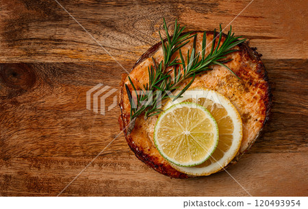 salmon steak, fried, on a cutting board, top view, rosemary, lemon and lime, homemade, one serving, no people, salmon steak, fried, on a cutting board, top view, rosemary, lemon and lime, homemade, one serving, no people, 120493954