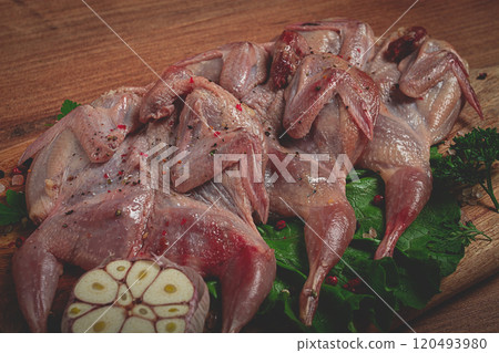 Raw quail meat, on a cutting board, with spices and herbs, top view, 120493980