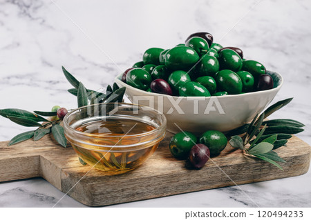 Chalkidiki olives, classic Greek green olives, in a bowl on a cutting board, top view, without people, Chalkidiki olives, classic Greek green olives, in a bowl on a cutting board, top view, without people, 120494233