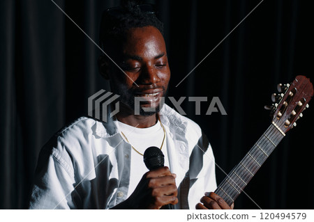 Singing and Playing Guitar on Stage in Spotlight 120494579