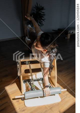 Comprehensive Pilates training session that includes essential posture correction. Exercises to improve mobility on a Pilates chair Comprehensive Pilates training session that includes essential posture correction. Exercises to improve mobility on a Pilates chair 120494844