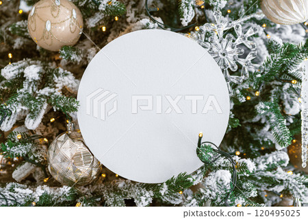 White blank paper circle on festive decorated Christmas tree background. Mockup, template copy space 120495025
