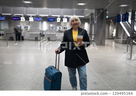 Adult woman traveller with hand luggage, backpack holds passport and waits for flight travel at international airport terminal. Middle aged female go to foreign country for holiday. Flight schedule Adult woman traveller with hand luggage, backpack holds passport and waits for flight travel at international airport terminal. Middle aged female go to foreign country for holiday. Flight schedule 120495164