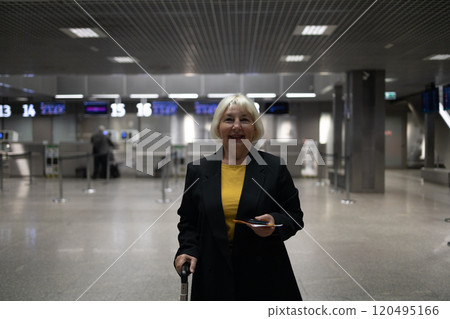 Adult woman traveller with hand luggage, backpack holds passport and waits for flight travel at international airport terminal. Middle aged female go to foreign country for holiday. Flight schedule Adult woman traveller with hand luggage, backpack holds passport and waits for flight travel at international airport terminal. Middle aged female go to foreign country for holiday. Flight schedule 120495166