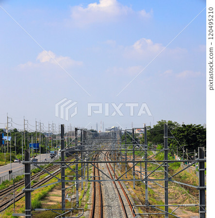 Aerial view of Infrastructure of railway tracks equipped with overhead electric poles in parallel to high powered supply lines in suburban. Aerial view of Infrastructure of railway tracks equipped with overhead electric poles in parallel to high powered supply lines in suburban. 120495210
