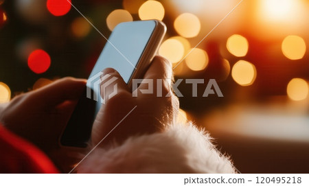 Santa Claus hand holding smartphone blurred golden Christmas lights festive 120495218