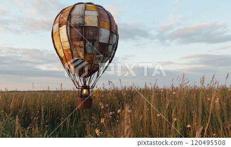 Floating hot air balloon in a rural field 120495508