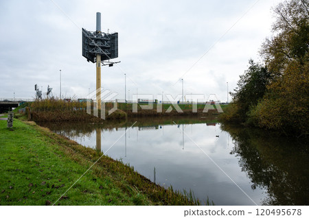 The highway reflecting in a water pond at the industrial zone Westpoort, Amsterdam, The Netherlands 120495678