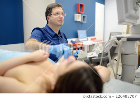 Mammologist doctor examines a woman breasts and lymph nodes using ultrasound. Mammography and ultrasound scanning are main methods of instrumental diagnosis of mammary glands. Breast cancer 120495707
