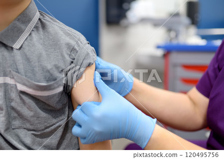 A boy is being vaccinated. A child is given a vaccine during an epidemic or outbreak of a disease. A boy is being vaccinated. A child is given a vaccine during an epidemic or outbreak of a disease. 120495756