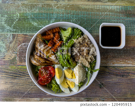 A beautiful bowl of food containing porridge, eggs, chopped chicken pieces, lettuce, carrots, tomatoes. Delicious and healthy food. Proper nutrition. A beautiful bowl of food containing porridge, eggs, chopped chicken pieces, lettuce, carrots, tomatoes. Delicious and healthy food. Proper nutrition. 120495915
