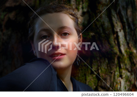 Young Woman Relaxing by Tree in Natural Light Young Woman Relaxing by Tree in Natural Light 120496604