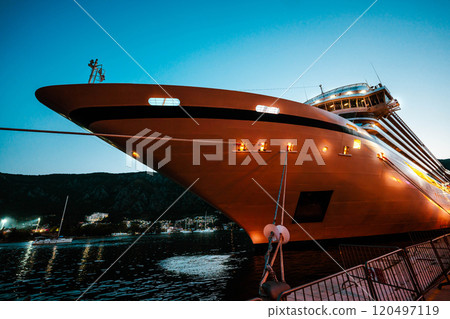 A grand cruise ship moored at sunset, its lights glowing against the twilight sky, embodying elegance and maritime exploration. A grand cruise ship moored at sunset, its lights glowing against the twilight sky, embodying elegance and maritime exploration. 120497119