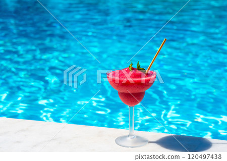 Refreshing frozen drink in cocktail glass by pool. Concept of summer vacation relaxation outdoors Refreshing frozen drink in cocktail glass by pool. Concept of summer vacation relaxation outdoors 120497438
