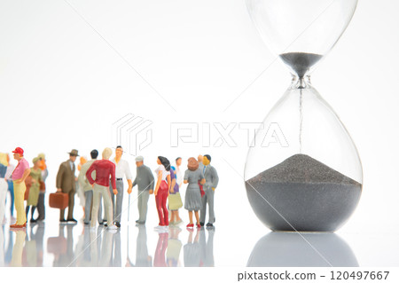miniature people. people of different ages and statuses stand in line near the hourglass miniature people. people of different ages and statuses stand in line near the hourglass 120497667