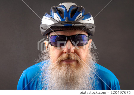 close-up portrait of a cyclist with a large white beard wearing a bicycle helmet and glasses  120497675