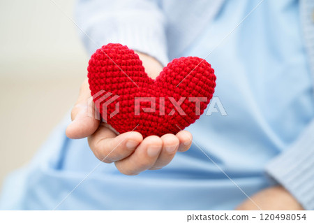 Asian elder senior woman patient holding red heart in hospital. 120498054