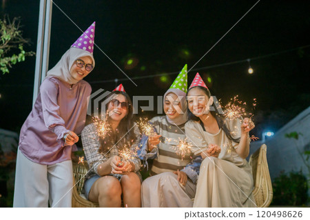 A Joyful Celebration with Friends and Colorful Sparklers at a Night Party Event 120498626