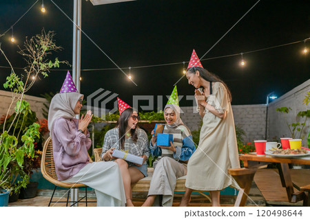 Friends Joyfully Celebrate in Party Hats Under the Beautiful Night Sky Friends Joyfully Celebrate in Party Hats Under the Beautiful Night Sky 120498644