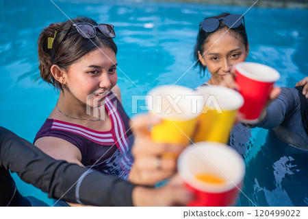 A Joyful Celebration by the Poolside with Friends and Bright, Colorful Cups 120499022