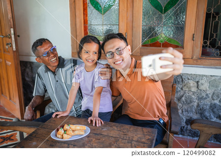 happy asian man taking picture with father and daughter 120499082